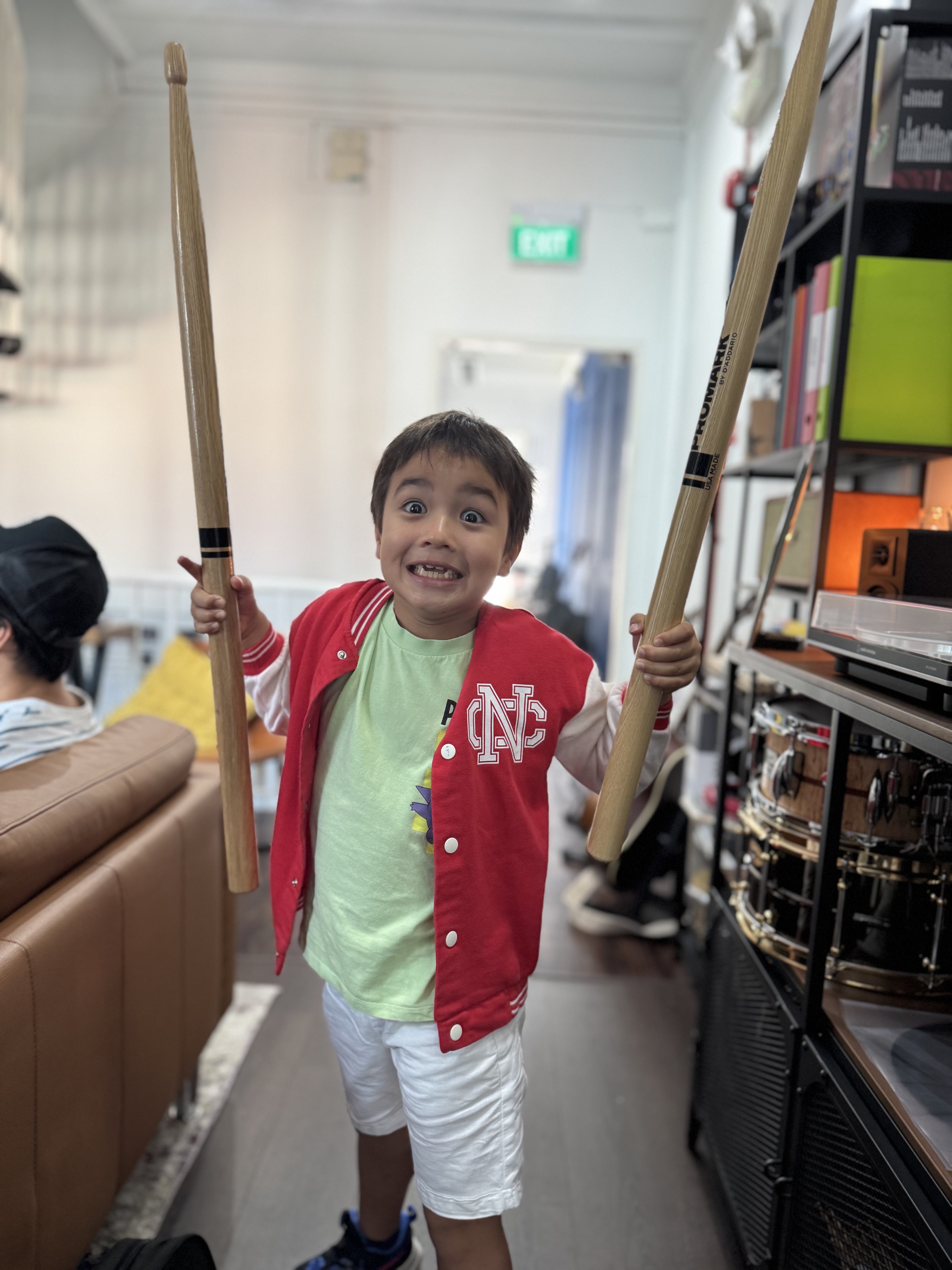 Young student excited with drumsticks